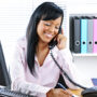 Smiling black businesswoman on phone at desk
